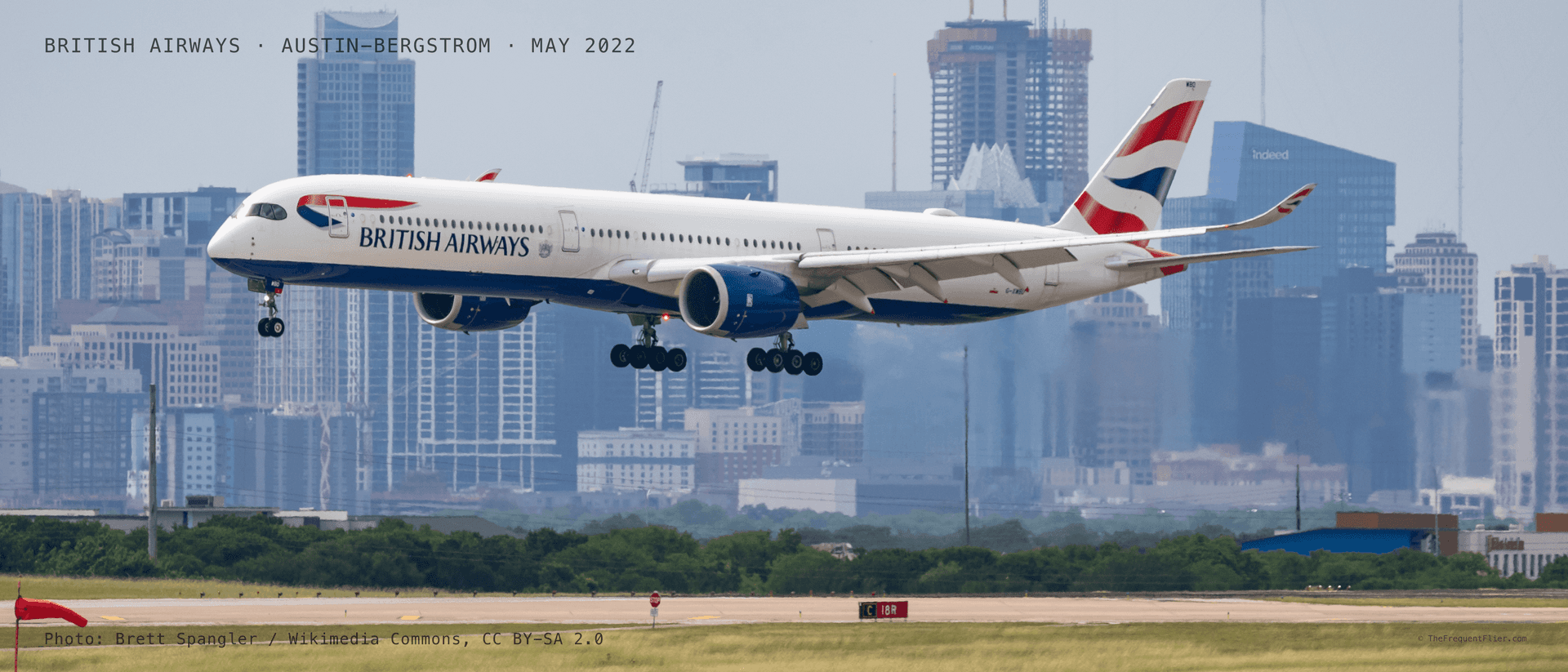 A British Airways Airbus A350 on final approach to Austin-Bergstrom International Airport, with the downtown Austin skyline behind it.